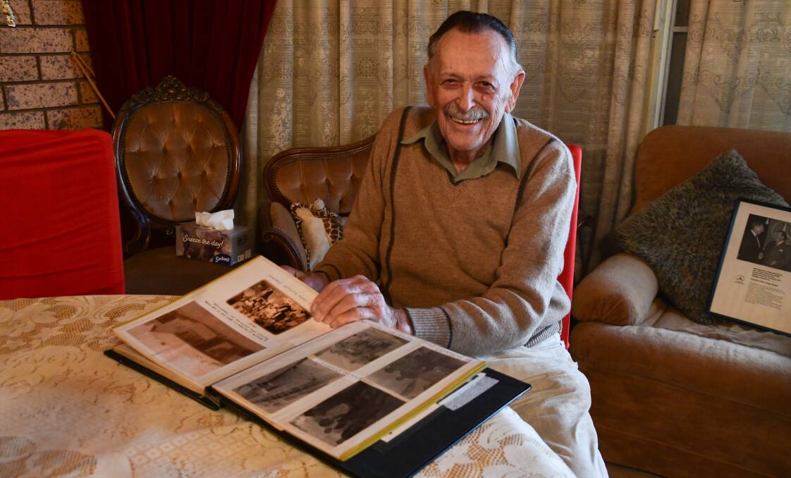 Fred Graf looking over his photo album full of memories. Picture by Carla Freedman