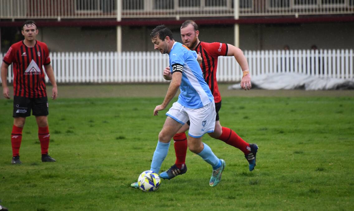 Macquarie United new recruit and captain Jamie Lobb keeps Panorama's Ryan Peacock at bay during Saturday's WPL battle. Picture by Amy McIntyre