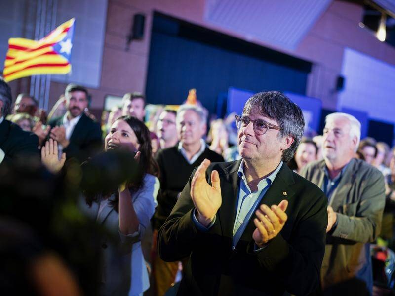 Catalonia's fugitive former leader Carles Puigdemont applauds during a campaign rally in France. (AP PHOTO)
